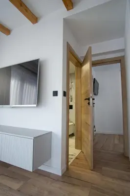 a room with a door and a television on a wall at Apartament Mikołaja w Rabce in Rabka