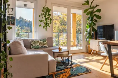 a living room with a couch and a table at GREEN OASIS - free parking, big balcony, private park in Kraków
