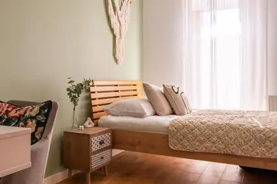 a bedroom with a bed and a chair and a window at GREEN OASIS - free parking, big balcony, private park in Kraków