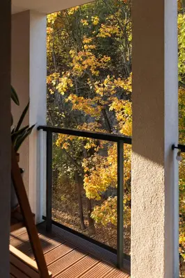 a balcony with a view of the fall foliage at GREEN OASIS - free parking, big balcony, private park in Kraków