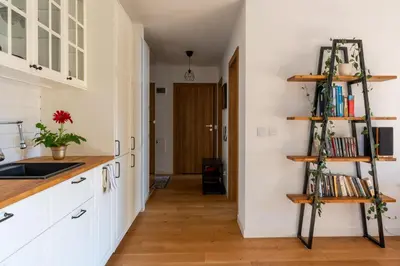 a kitchen with white cabinets and wooden shelves at GREEN OASIS - free parking, big balcony, private park in Kraków