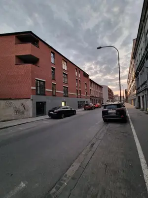 two cars driving down a city street with buildings at Apartment in the heart of Old Podgórze in Kraków