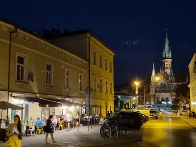 a group of people walking down a city street at night at Apartment in the heart of Old Podgórze in Kraków