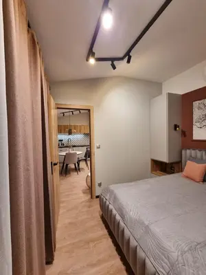 a bedroom with a bed and a dining room at Apartment in the heart of Old Podgórze in Kraków