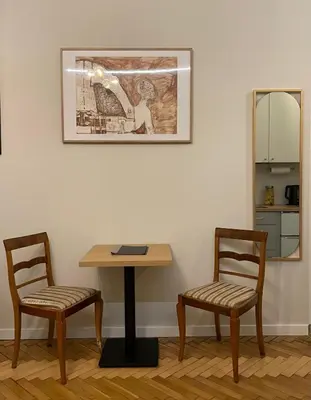 a table and two chairs in a room with a mirror at Apartament studio z widokiem na Rynek in Bochnia
