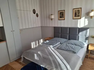 a bed with blue pillows in a bedroom at Apartament studio z widokiem na Rynek in Bochnia