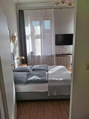 a bedroom with a bed and a window and a television at Apartament studio z widokiem na Rynek in Bochnia