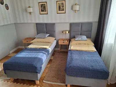 two twin beds in a room with blue blankets at Apartament studio z widokiem na Rynek in Bochnia