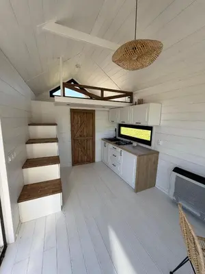 a small kitchen with a staircase in a tiny house at Domek na Odludziu - Tiny House in Spytkowice