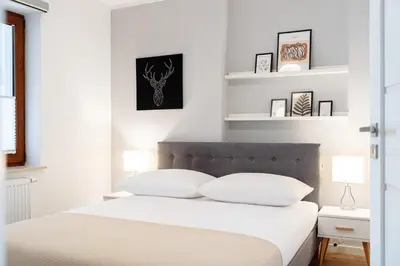 a bedroom with a white bed with white pillows at Native Apartments Barska 13 in Kraków