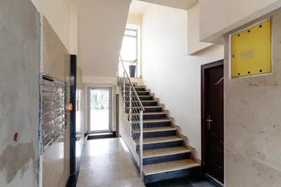a staircase in a house with a yellow sign on the wall at Native Apartments Barska 13 in Kraków
