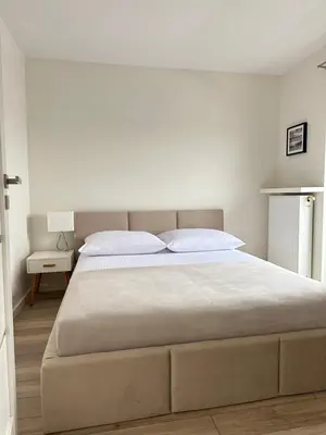 a bedroom with a large bed and a white wall at Native Apartments Barska 13 in Kraków