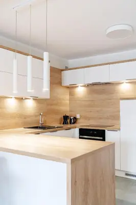 a kitchen with white cabinets and a counter top at Native Apartments Barska 13 in Kraków