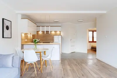 a kitchen and living room with a table and chairs at Native Apartments Barska 13 in Kraków