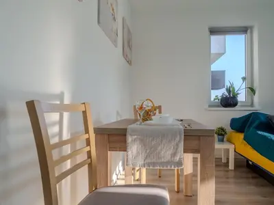 a dining room with a table and a chair at Miły Pobyt w mieście in Kraków