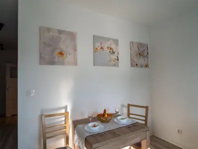 a dining room with a table and three paintings on the wall at Miły Pobyt w mieście in Kraków