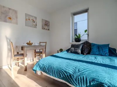 a bedroom with a bed and a table and a window at Miły Pobyt w mieście in Kraków