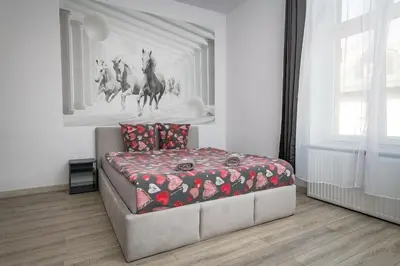 a bedroom with a bed and a painting of horses on the wall at 70s Business Room in Kraków