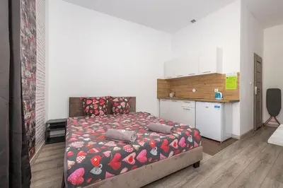 a bedroom with a bed and a kitchen at 70s Business Room in Kraków