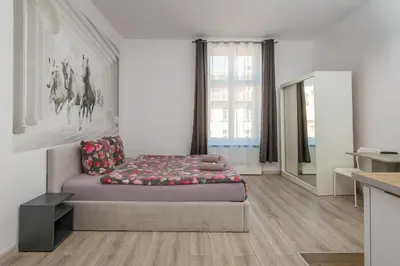 a bedroom with a bed and a large window at 70s Business Room in Kraków
