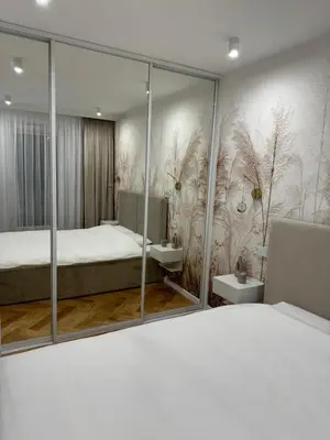 a bedroom with a bed and a large mirror at Luxury Apartments in Kraków