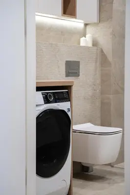 a bathroom with a washing machine and a toilet at Luxury Apartments in Kraków