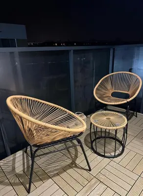 two wicker chairs and a table on a balcony at Luxury Apartments in Kraków