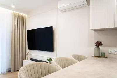 a living room with chairs and a television on the wall at Luxury Apartments in Kraków