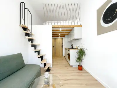 a living room with a green couch and a staircase at Nad Szklarnią in Kraków
