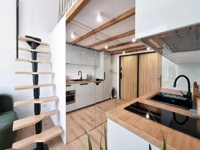 a kitchen with white cabinets and a black sink at Nad Szklarnią in Kraków