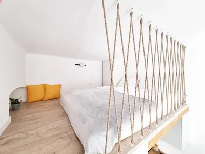 a bedroom with a hanging bed in a white room at Nad Szklarnią in Kraków