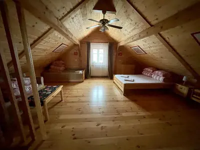 an attic room with a ceiling fan and a bed at Zacisze Pod Lipą in Andrychów