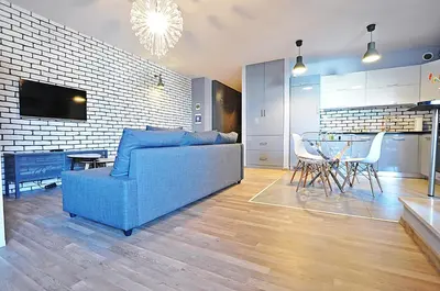 a living room with a blue couch and a table at Designomania Apartments - Nadwiślańska 11 in Kraków