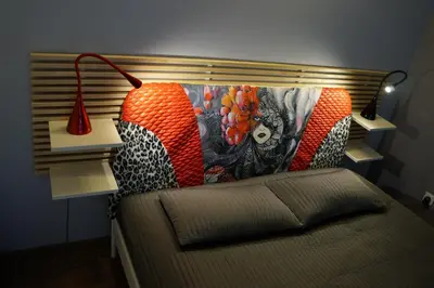 a room with a bed with a headboard with a lamp at Designomania Apartments - Nadwiślańska 11 in Kraków
