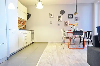 a kitchen and dining room with a table and chairs at Designomania Apartments - Nadwiślańska 11 in Kraków