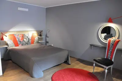 a bedroom with a bed and a mirror and a chair at Designomania Apartments - Nadwiślańska 11 in Kraków