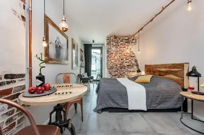 a bedroom with a bed and a brick wall at Rajska Old Town Suites in Kraków