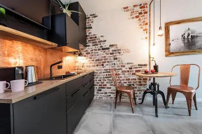 a kitchen with a brick wall and a table at Rajska Old Town Suites in Kraków