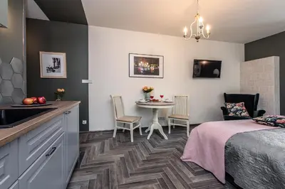 a room with a bed and a table with chairs at Rajska Old Town Suites in Kraków