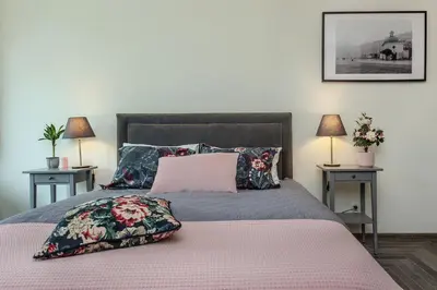 a bedroom with a large bed with two tables at Rajska Old Town Suites in Kraków
