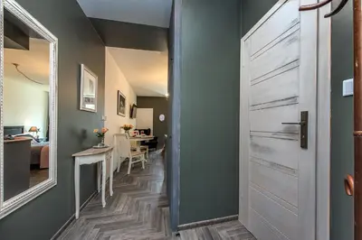 a hallway with a door leading to a living room at Rajska Old Town Suites in Kraków