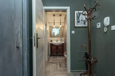 a hallway with a bathroom with a sink and a toilet at Rajska Old Town Suites in Kraków