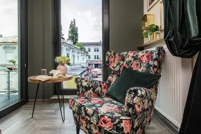 a living room with a chair and a window at Rajska Old Town Suites in Kraków