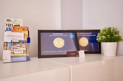 a tv sitting on a counter with books and a plant at Kraków Apartments - Friedleina Studio Apartments in Kraków