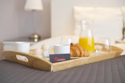 a tray of food with eggs and bread and a bottle of orange juice at Kraków Apartments - Friedleina Studio Apartments in Kraków
