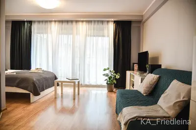 a bedroom with a bed and a couch and a window at Kraków Apartments - Friedleina Studio Apartments in Kraków