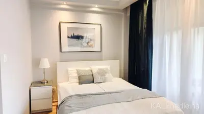 a bedroom with a white bed and a window at Kraków Apartments - Friedleina Studio Apartments in Kraków