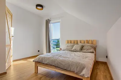 a bedroom with a bed with a large window at Stodołówka in Budzów