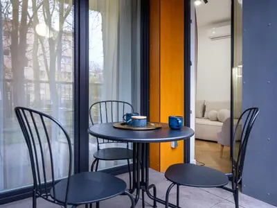 a table and chairs in a room with a window at Luxury two-bedroom apartment with terrace by Tyzenhauz in Kraków