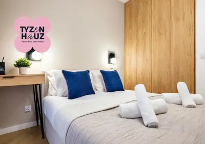 a bedroom with a large bed with blue and white pillows at Luxury two-bedroom apartment with terrace by Tyzenhauz in Kraków